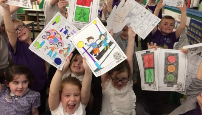 Children holding colouring sheets
